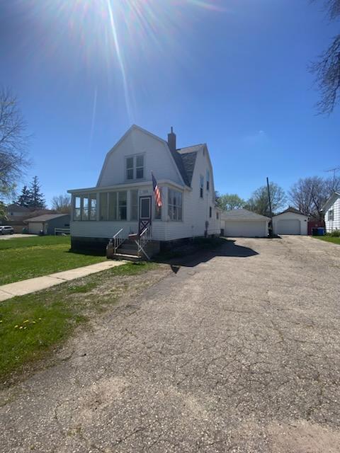 528 Broadway St, Spring Valley, MN 55975 - dutch colonial featuring a chimney, a gambrel roof, and a detached garage