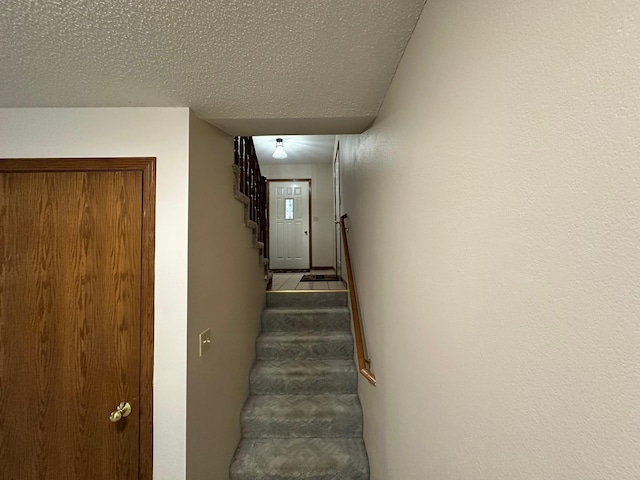 stairs with a textured ceiling