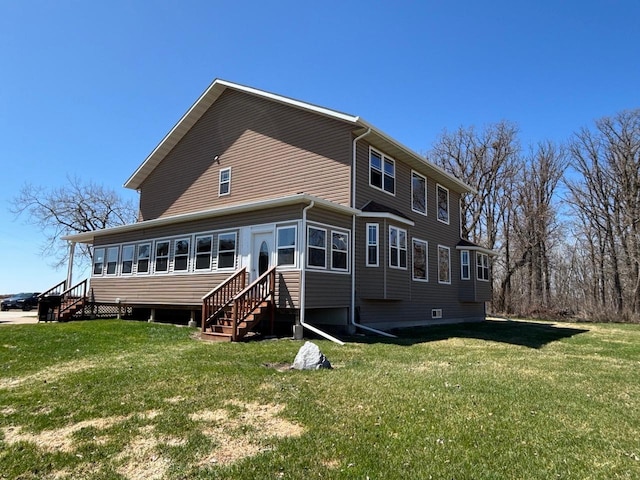 rear view of property featuring a yard and entry steps