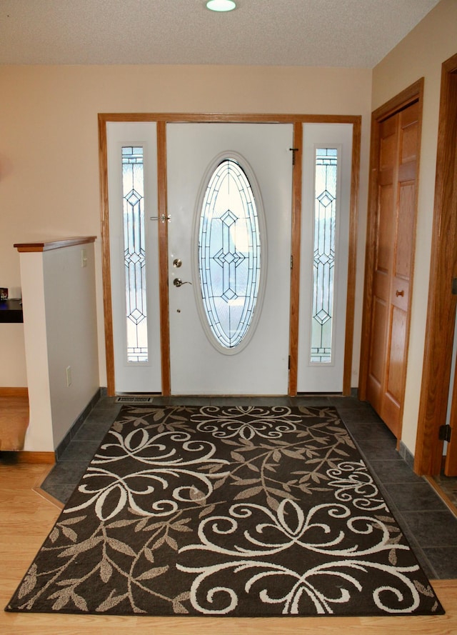 entryway featuring a textured ceiling and baseboards