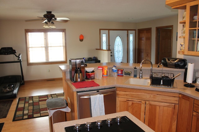 kitchen with ceiling fan, stainless steel dishwasher, a sink, light countertops, and light wood-style flooring