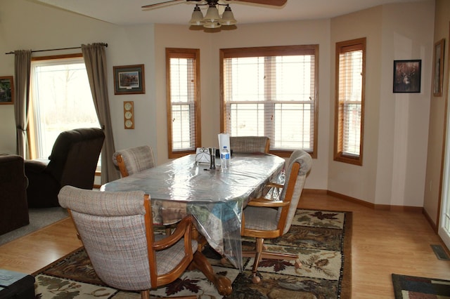 dining area with plenty of natural light, light wood-style flooring, ceiling fan, and baseboards