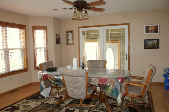 dining space with baseboards, ceiling fan, french doors, and wood finished floors