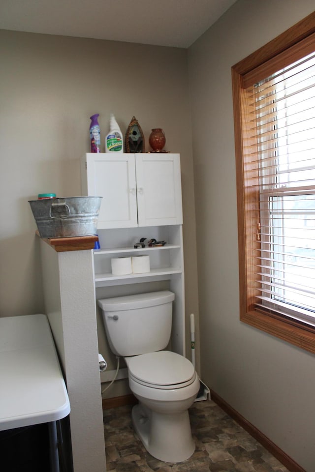 bathroom with toilet and baseboards