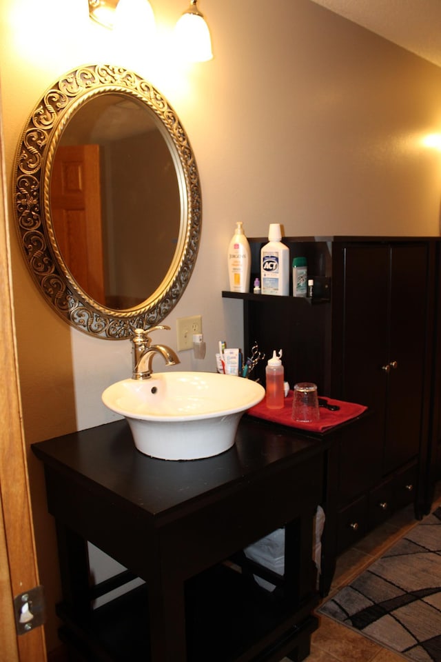 bathroom with a sink and lofted ceiling