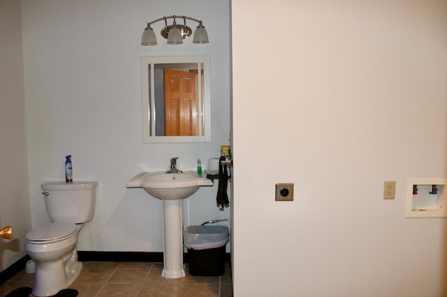 bathroom with tile patterned flooring, baseboards, and toilet