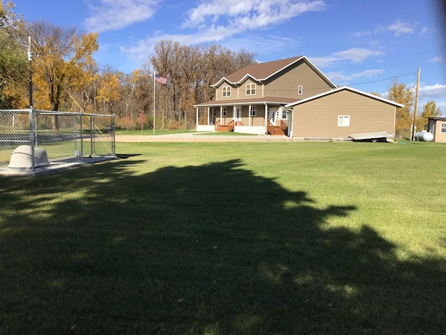rear view of property featuring a porch, a yard, and fence