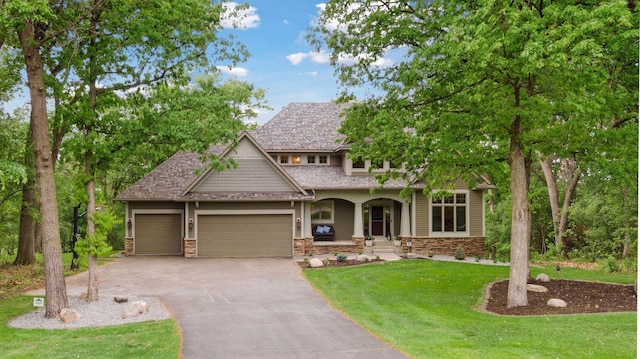 craftsman-style house with driveway, a front lawn, a garage, and covered porch