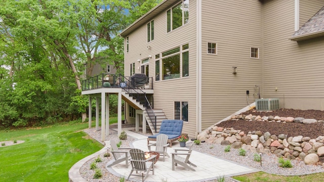 back of property featuring stairway, central air condition unit, a patio, a yard, and a wooden deck