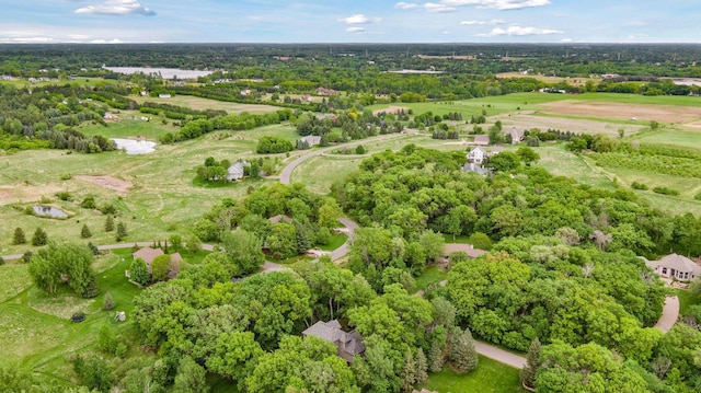 aerial view of property's location featuring a tree filled landscape and a large body of water