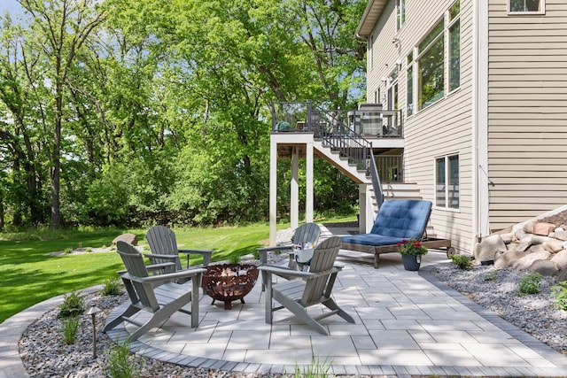 view of patio / terrace with an outdoor fire pit, stairs, and a deck