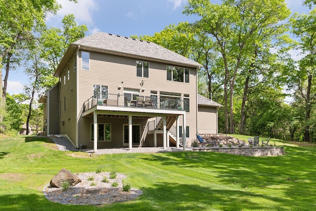 rear view of property featuring stairway, a wooden deck, a fire pit, and a yard