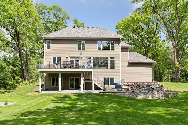 rear view of house featuring stairs, a wooden deck, a lawn, and a patio