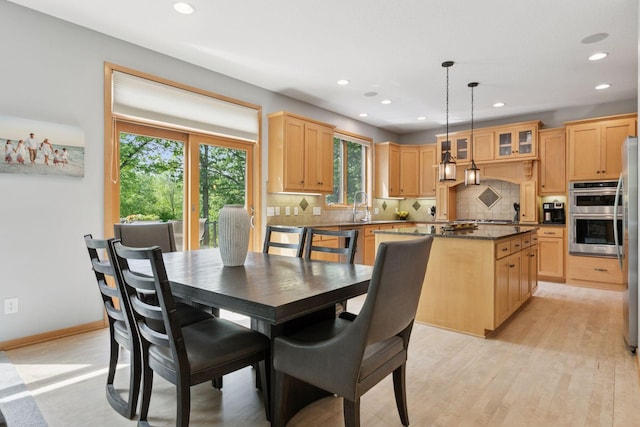 dining space featuring healthy amount of natural light, recessed lighting, light wood-type flooring, and baseboards