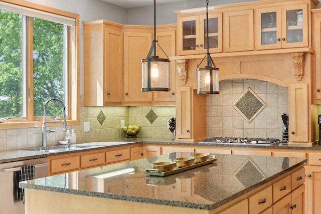 kitchen with appliances with stainless steel finishes, a kitchen island, a sink, and light brown cabinetry