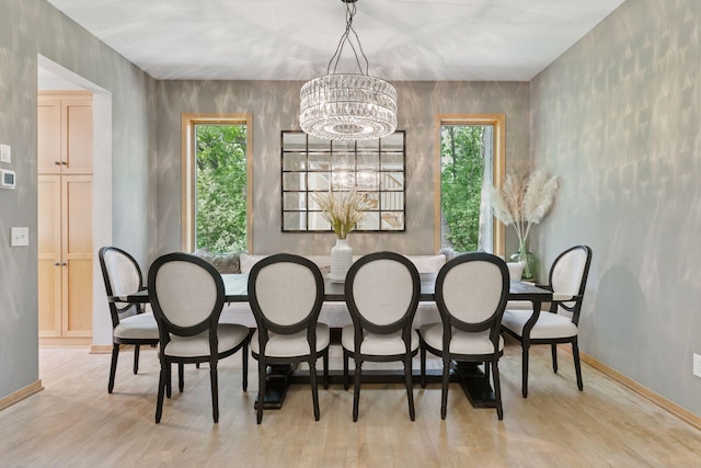 dining space with plenty of natural light, a chandelier, and wood finished floors