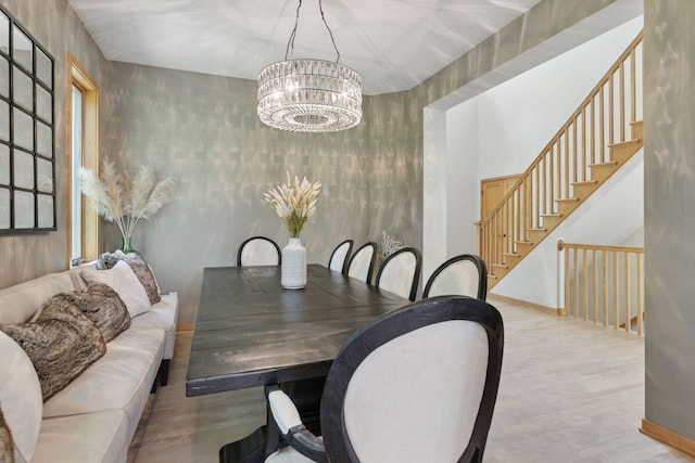 dining area with a chandelier, wood finished floors, stairs, and baseboards