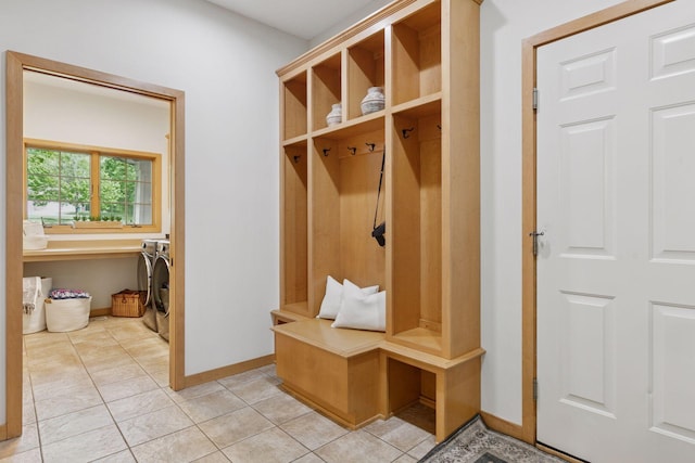 mudroom with washer and dryer, baseboards, and light tile patterned flooring