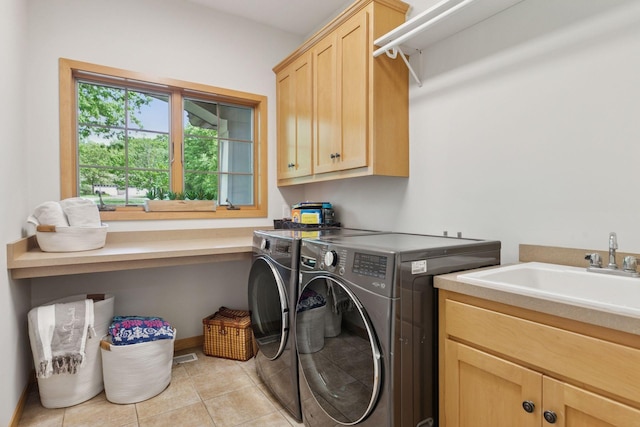 laundry area with cabinet space, washer and dryer, and light tile patterned floors