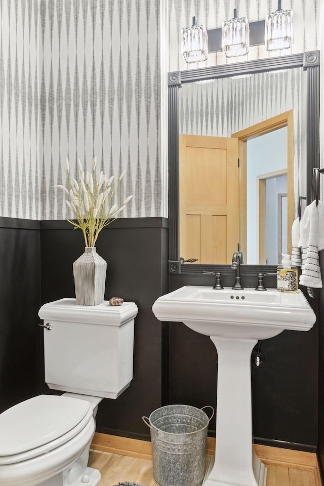 half bathroom featuring toilet and wood finished floors