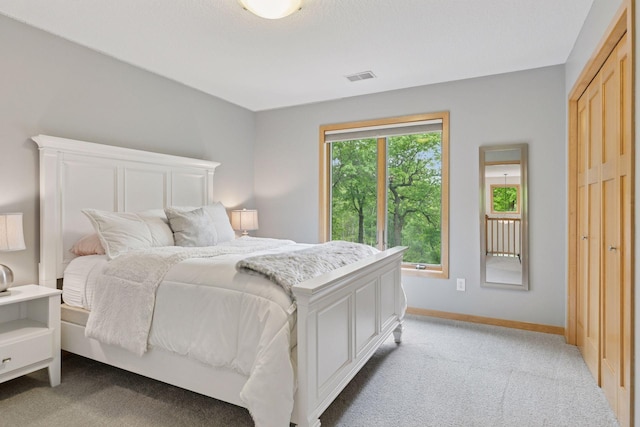 bedroom featuring light carpet and baseboards