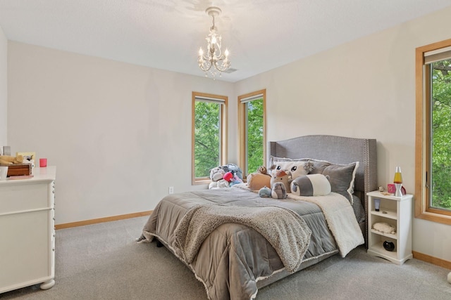 bedroom with a chandelier, light carpet, and baseboards