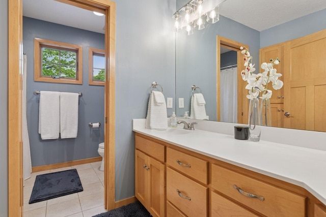 bathroom with tile patterned flooring, vanity, toilet, and baseboards