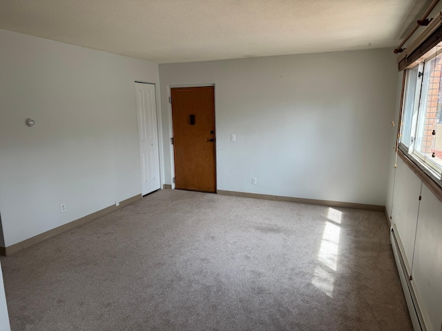 carpeted spare room with baseboards and baseboard heating