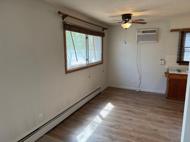 unfurnished room featuring a ceiling fan, light wood-style floors, baseboards, an AC wall unit, and a baseboard radiator