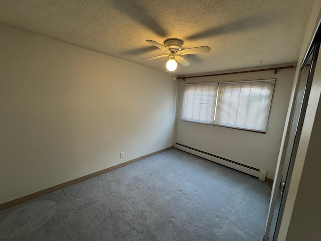 spare room featuring ceiling fan, light carpet, a textured ceiling, baseboards, and a baseboard radiator