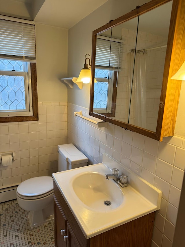 bathroom featuring toilet, tile patterned floors, tile walls, and vanity