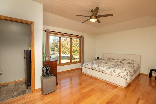 bedroom featuring baseboards, light wood-style flooring, and ceiling fan