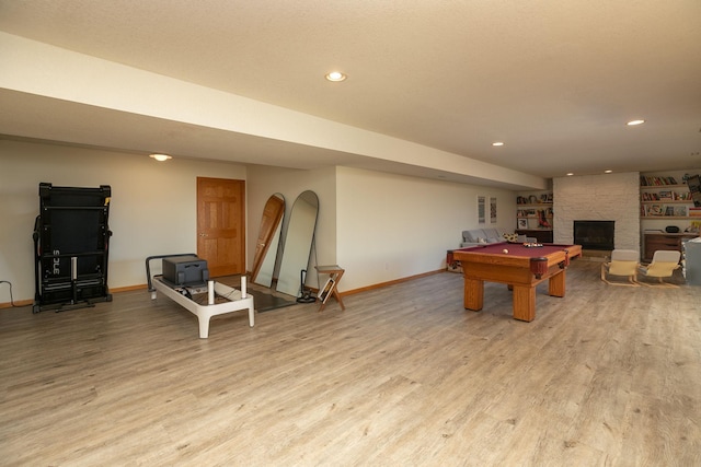 game room with baseboards, light wood finished floors, a large fireplace, and billiards