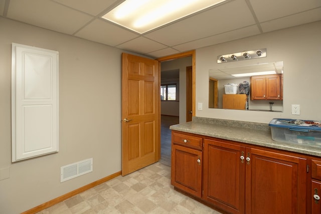 bathroom featuring tile patterned floors, baseboards, visible vents, and a drop ceiling
