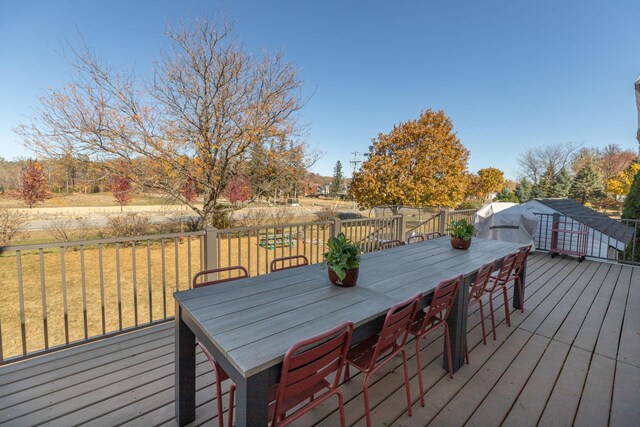 wooden terrace featuring a yard and outdoor dining space