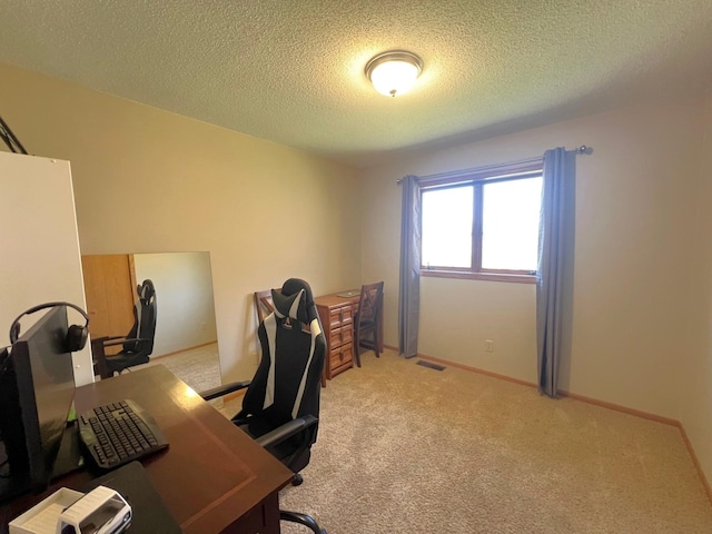 home office featuring light carpet and a textured ceiling
