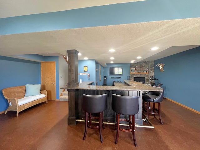 kitchen featuring a breakfast bar area, carpet, open floor plan, stone countertops, and a textured ceiling