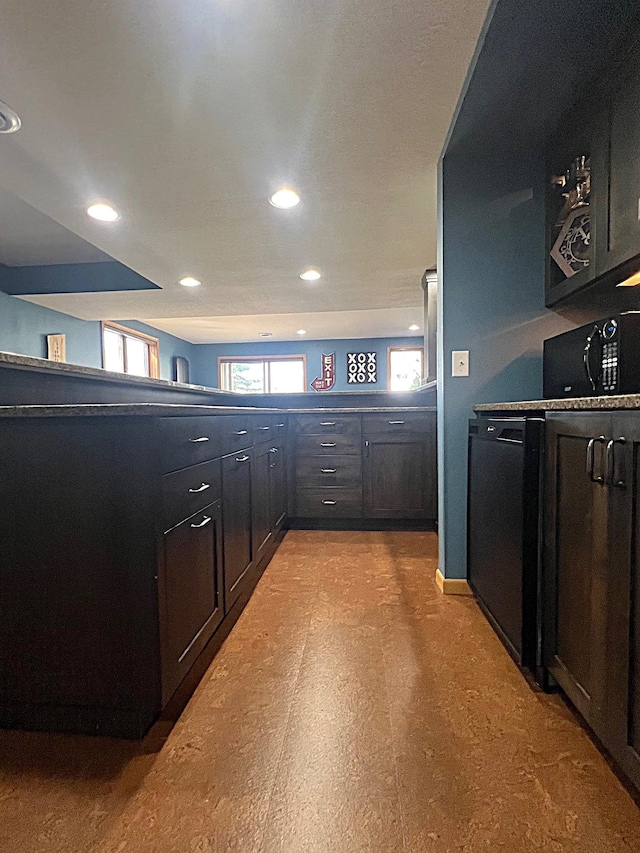 kitchen featuring black microwave, recessed lighting, light flooring, and dark cabinets