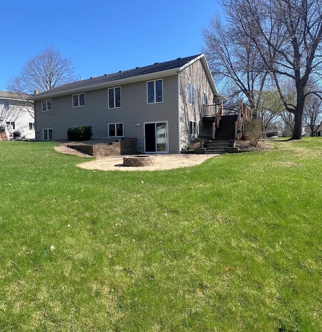 rear view of property with a deck, a patio area, a yard, and stairs