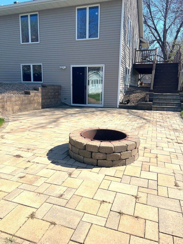 view of patio / terrace featuring an outdoor fire pit and stairway