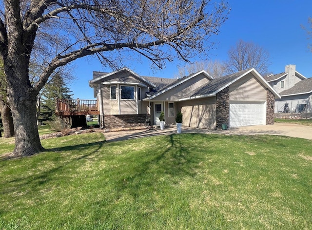 split level home with an attached garage, driveway, a front yard, and brick siding