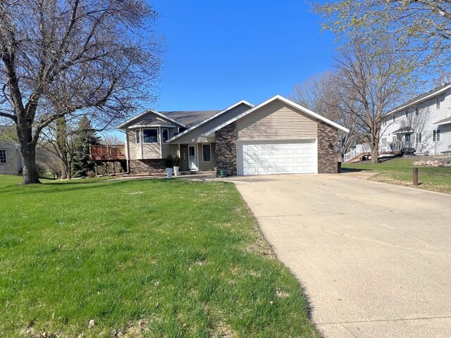 split level home featuring a garage, a front yard, and concrete driveway