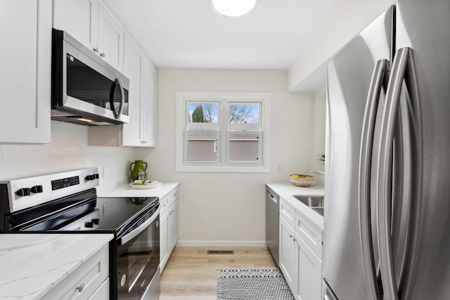 304 Lakeview Ave, Long Lake, MN 55356 - kitchen with white cabinetry, visible vents, light wood-style flooring, and appliances with stainless steel finishes