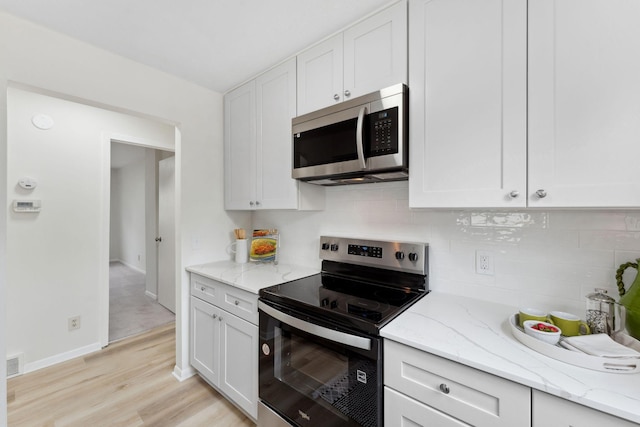 304 Lakeview Ave, Long Lake, MN 55356 - kitchen featuring white cabinetry, decorative backsplash, and appliances with stainless steel finishes