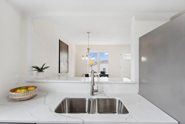 304 Lakeview Ave, Long Lake, MN 55356 - kitchen with a sink, light stone countertops, hanging light fixtures, and a notable chandelier