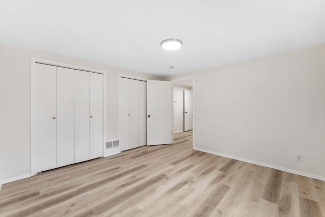 304 Lakeview Ave, Long Lake, MN 55356 - unfurnished bedroom featuring visible vents, light wood-style flooring, baseboards, and multiple closets