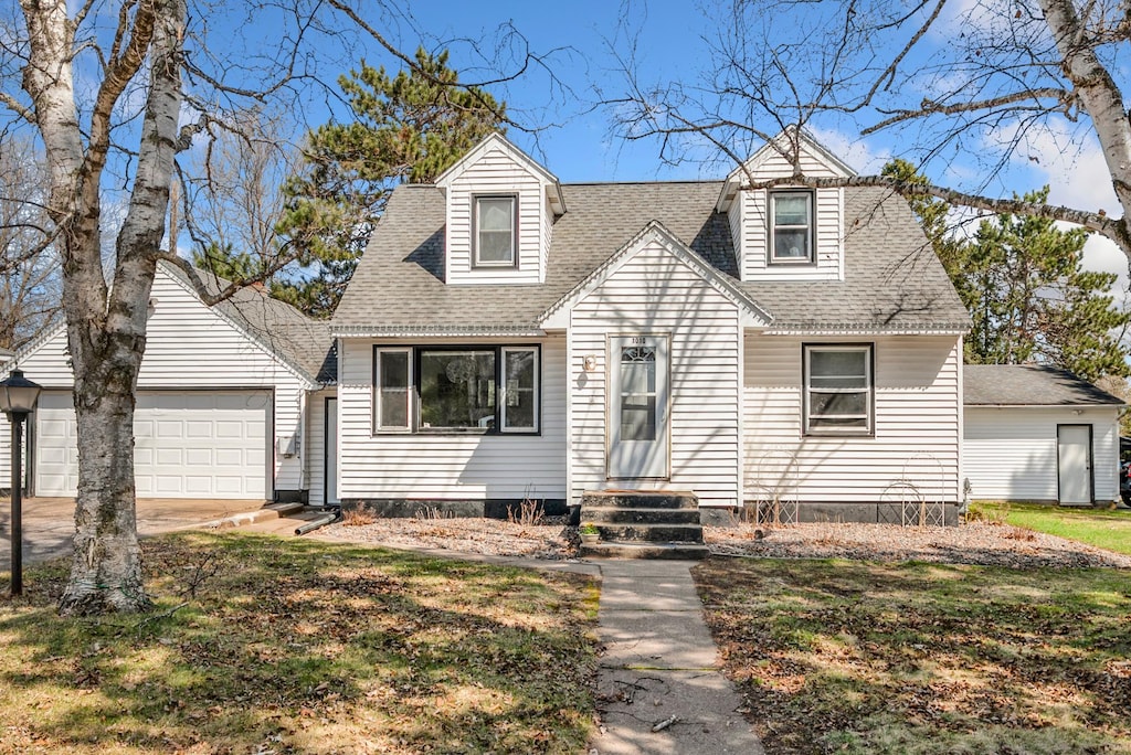 1010 14th St, Cloquet, MN 55720 - cape cod-style house featuring an attached garage, roof with shingles, driveway, and entry steps