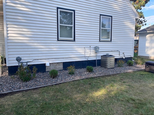 view of home's exterior featuring a lawn and central AC unit