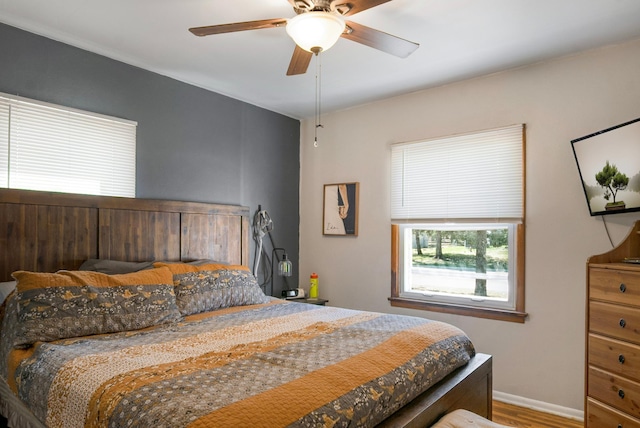 bedroom with baseboards, a ceiling fan, and wood finished floors