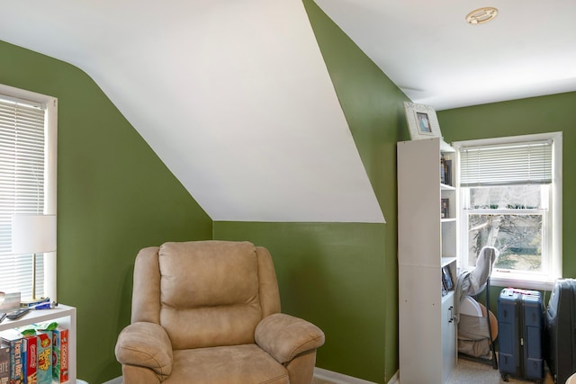 sitting room with baseboards and vaulted ceiling